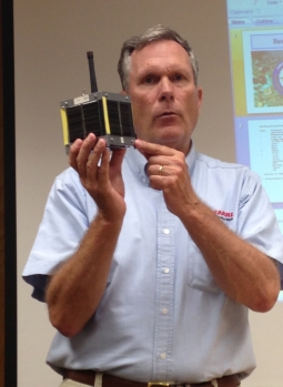 Mark displaying a model of an amateur radio satellite.